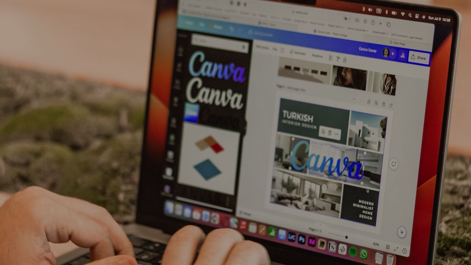 Close-up of hands typing on a laptop displaying graphic design software.