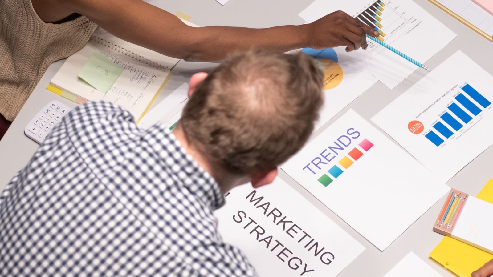 Team discussing marketing strategies in a modern office setting with charts and documents.