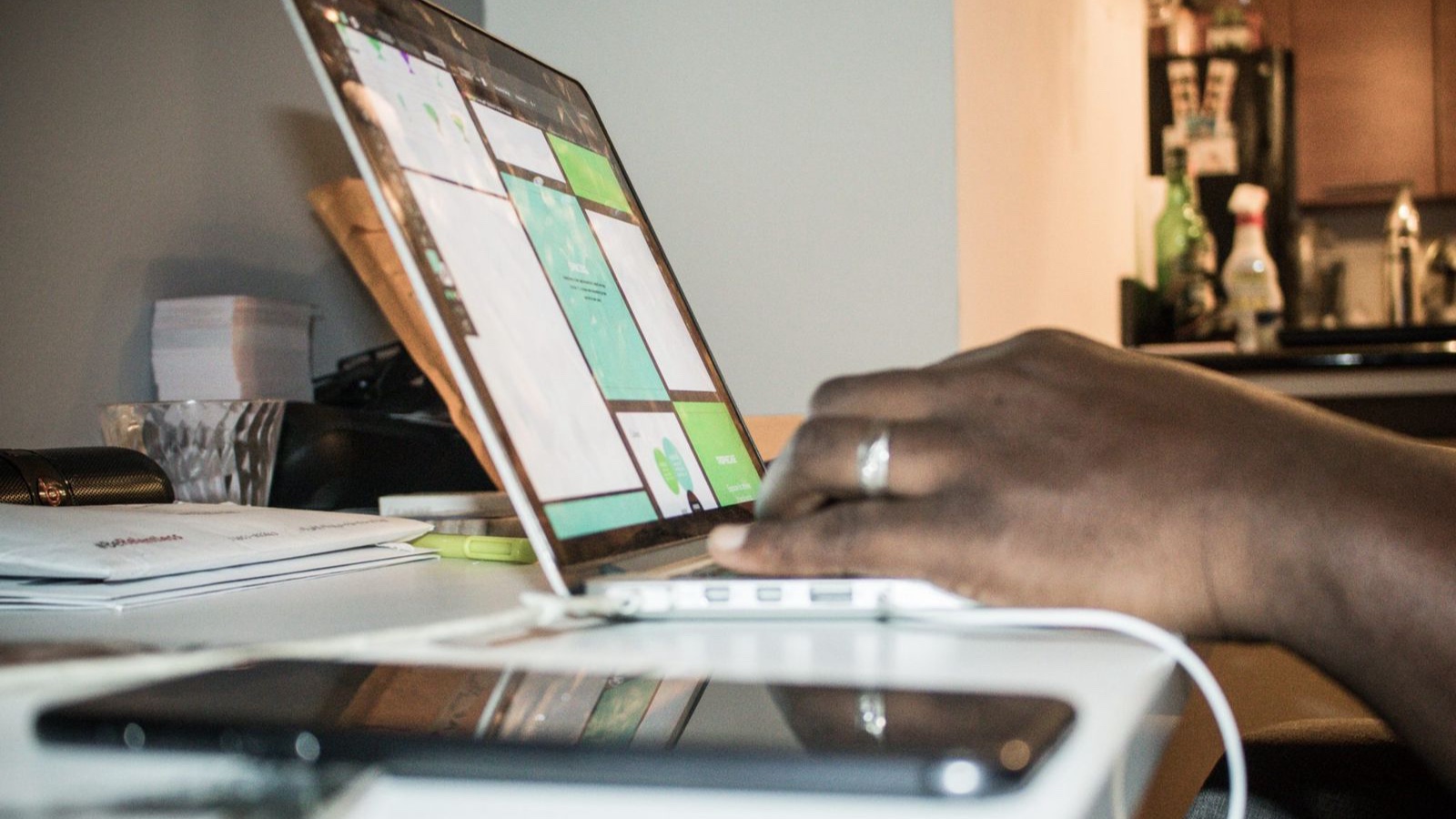Multilingual Websites: Connecting Translations and Page Addresses Focused setup of person working on a laptop in a home office environment with technology and documents.