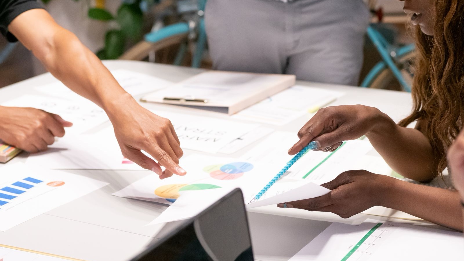 A diverse team collaborating on business strategies with charts and documents in an office setting.