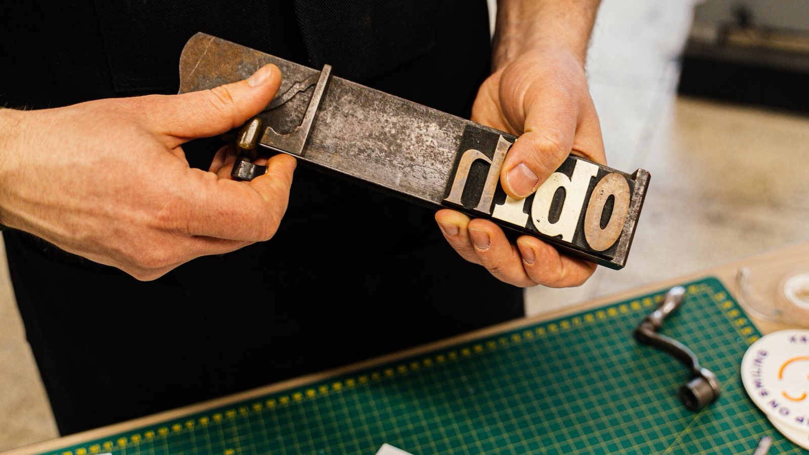Hands arranging metal letters for a typographic print