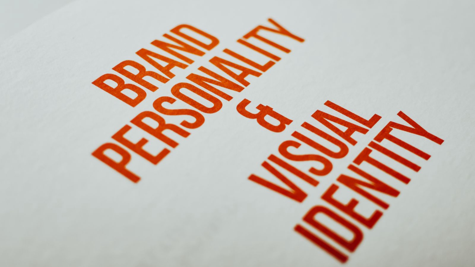 Writing a brand promise: Connecting the claim with delivery Orange brand personality and visual identity heading on white paper