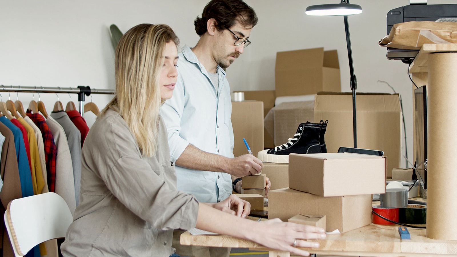Marketplace Integration: Critical Decisions in Product Mapping Two sellers preparing orders beside products and a computer