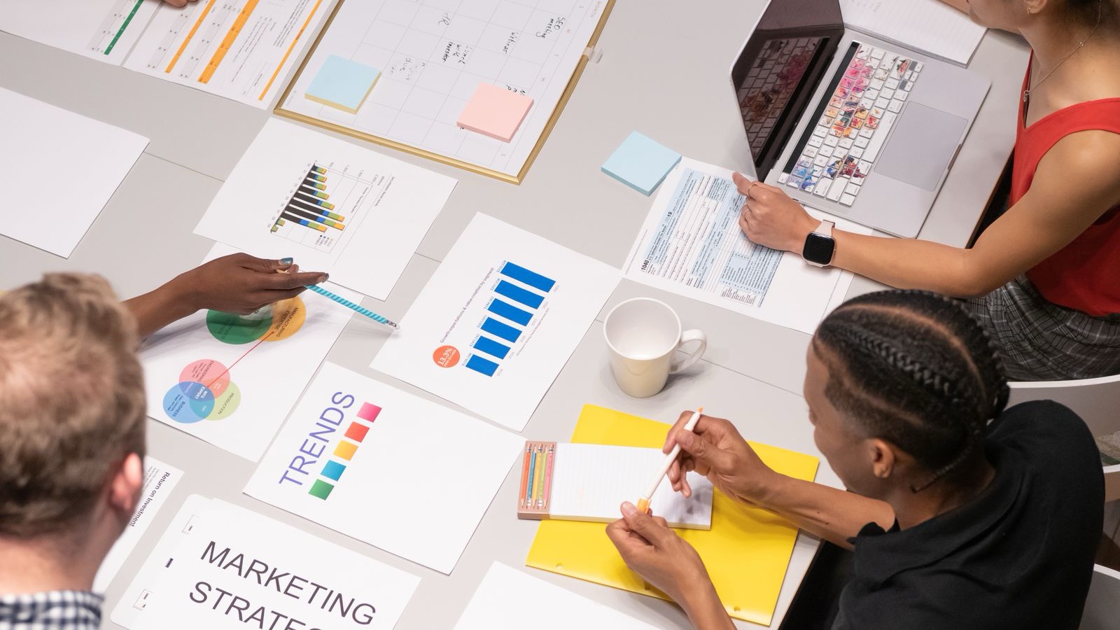 Social Media Approvals: Keep Review Clear and Publishing on Track Colleagues reviewing documents together at a table