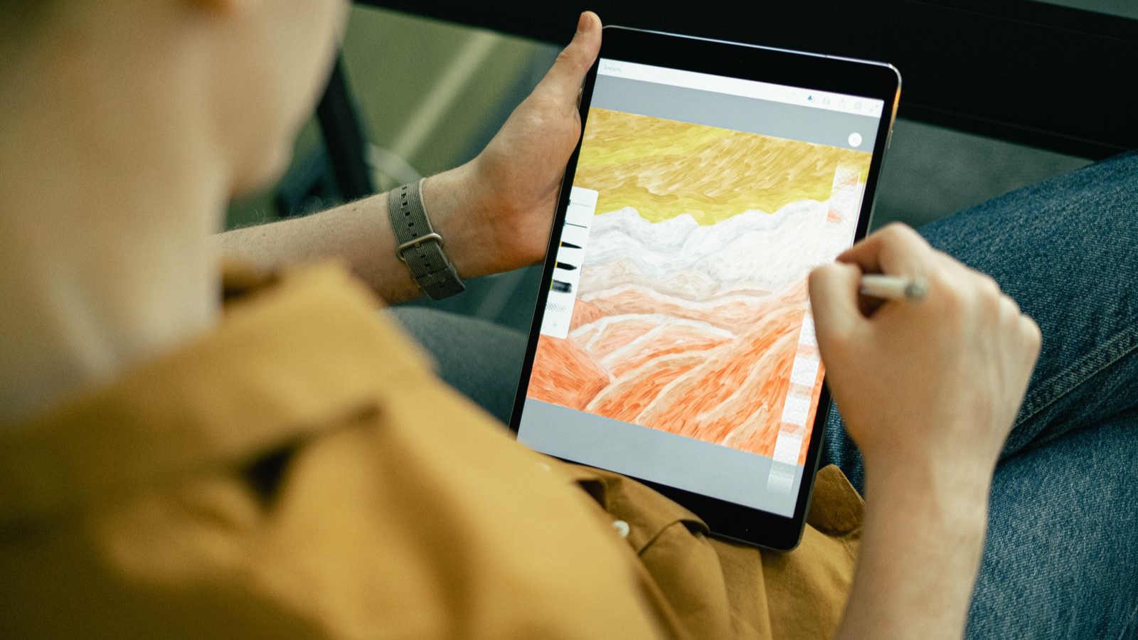 Design revisions: Turning scattered feedback into decisions A person drawing a colourful illustration on a tablet with a stylus