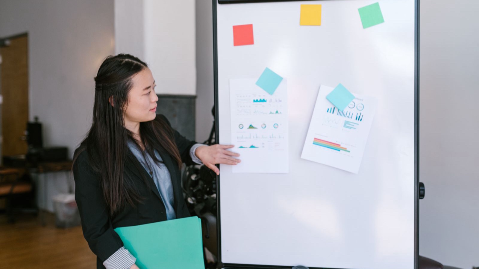 A person presenting an explanation beside a whiteboard