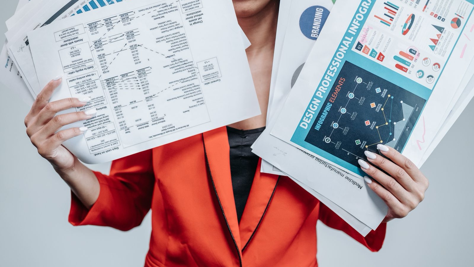 A person holding business documents and chart pages