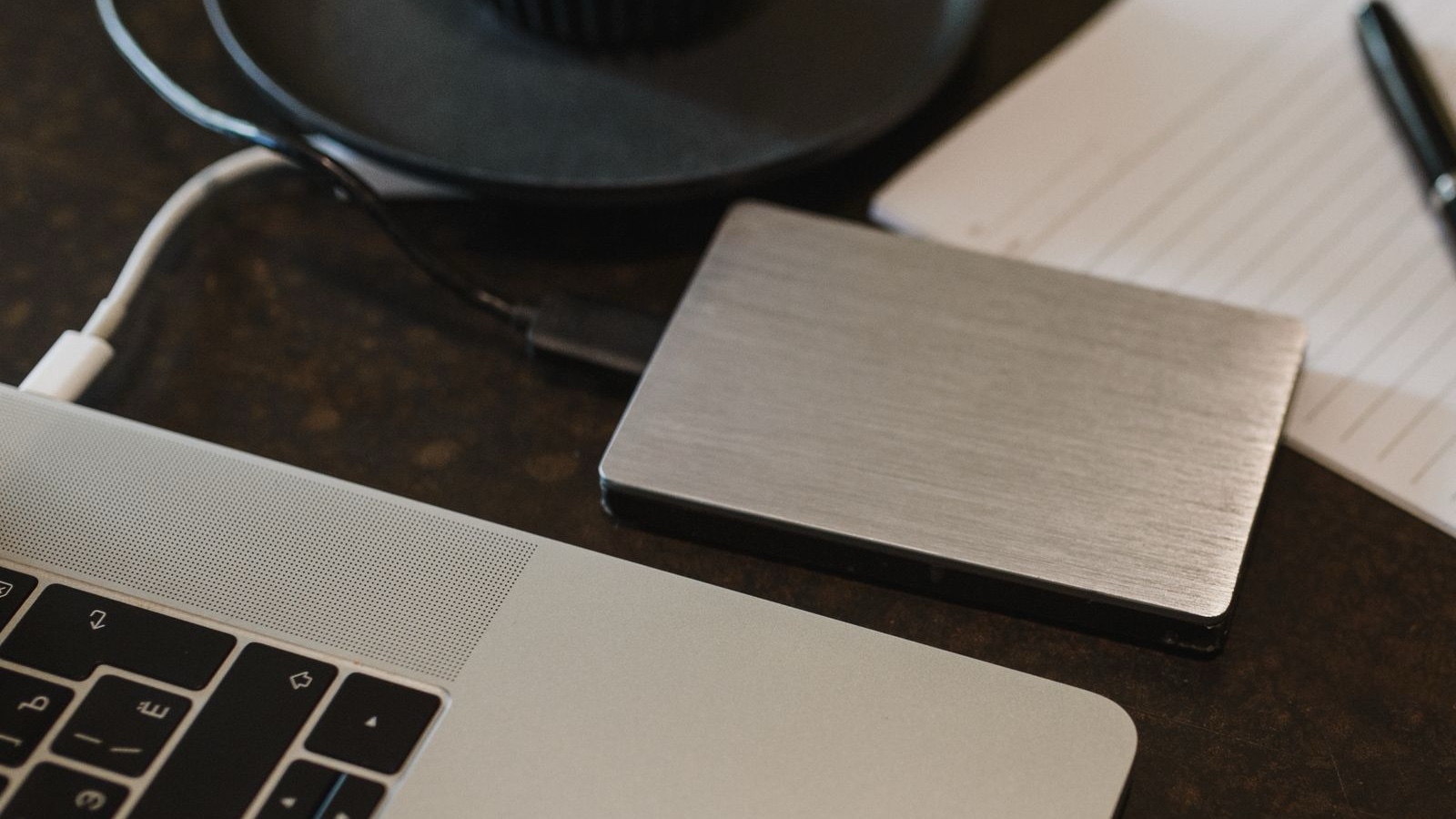 Backup and restoration: the practical test of software continuity A portable external drive connected to a laptop with a USB cable