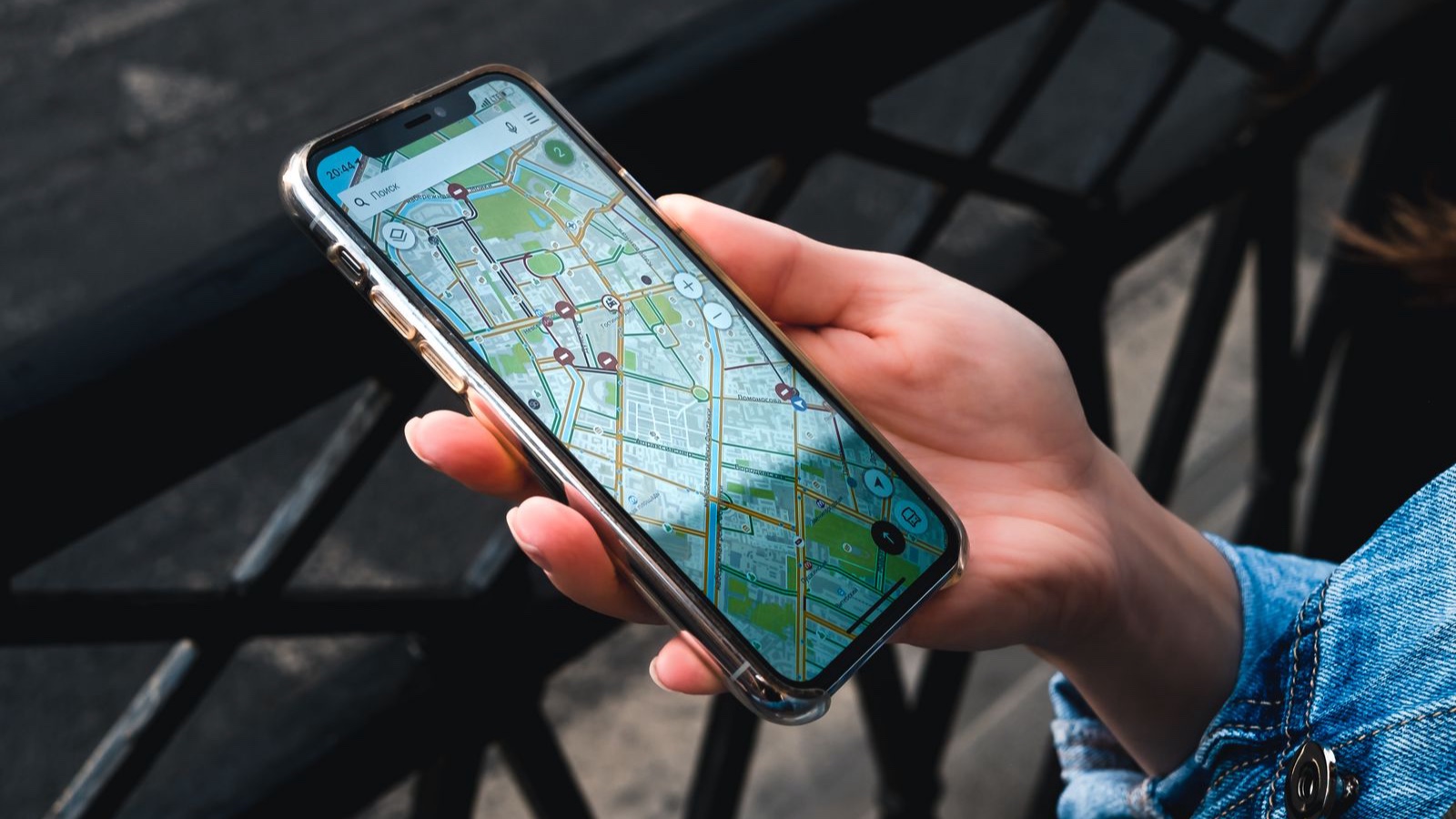 Local SEO and Websites: Presenting Ataşehir Business Information Accurately An outdoor close-up of a hand holding a smartphone displaying a map application.