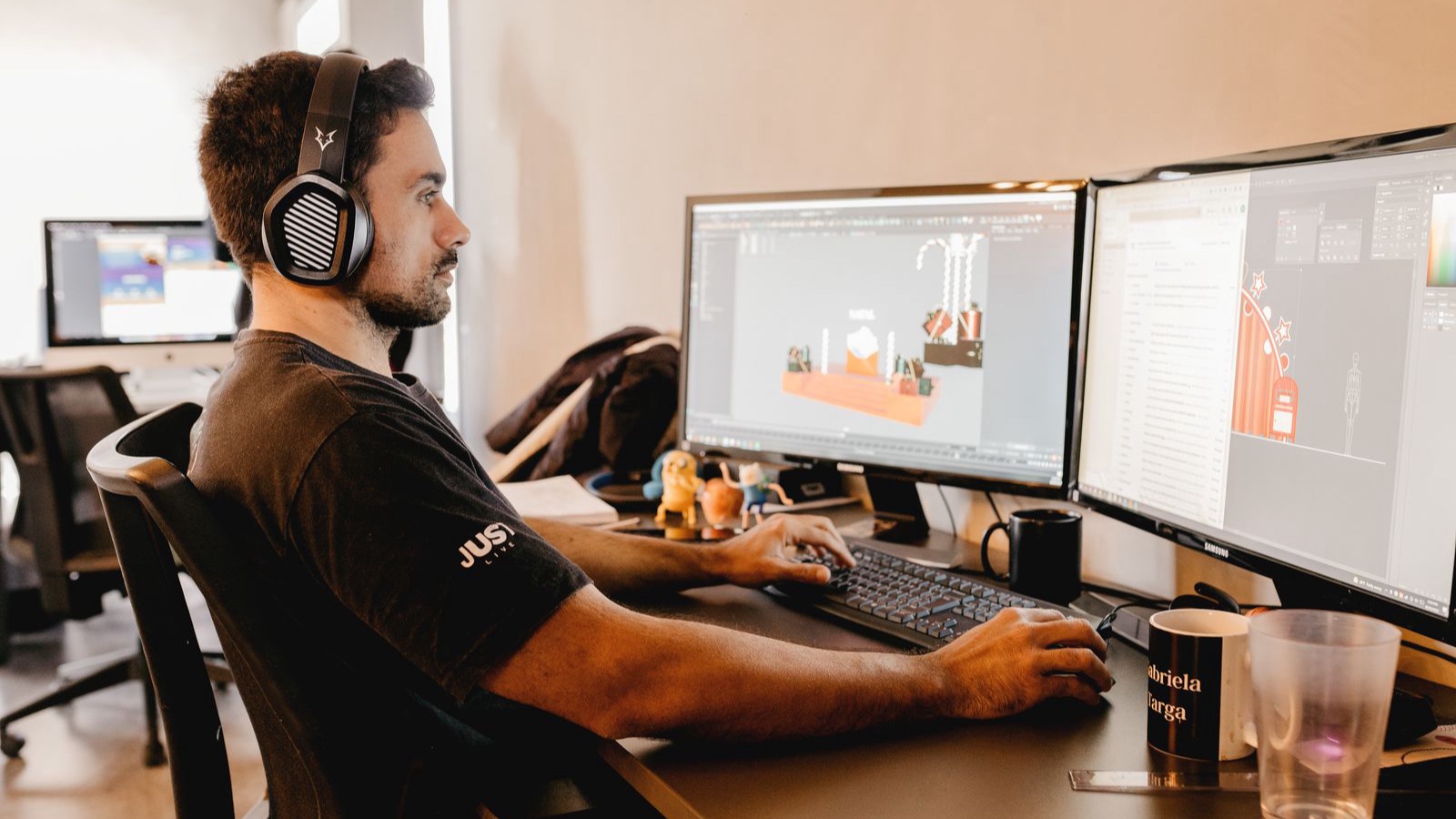 Choosing a Website CMS: Test the Editorial Tasks That Matter A man wearing headphones works on a computer with two monitors in a modern office setup.